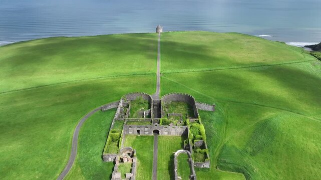 Luftaufnahme der Ruinen von Downhill House und des ikonischen Mussenden Temple, mit einem Weg, der zum Klippenrand f&uuml;hrt und den Blick auf das Meer in Nordirland freigibt