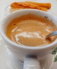 coffee with milk and churros on the table
