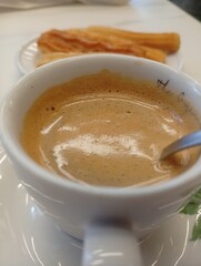coffee with milk and churros on the table