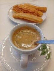 coffee with milk and churros on the table