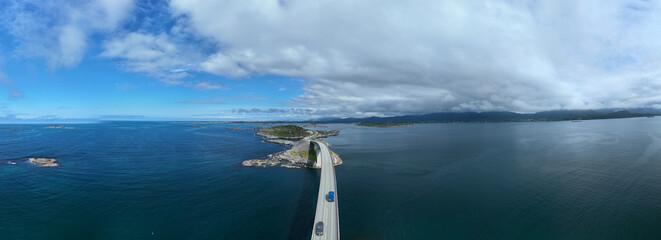 Spectacular landscape showcases the winding Atlantic Ocean Road in Norway, surrounded by tranquil...