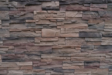 A wall made of stone blocks with a brown and gray color