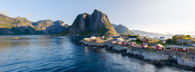 Hamnoy showcases picturesque fishing cabins along the waters edge, framed by majestic peaks and...