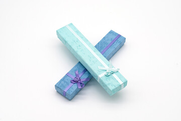 Two boxes of gifts, one pink and one blue, with ribbons tied around them