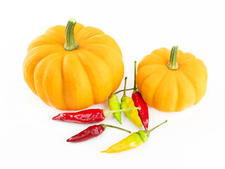 A couple of orange pumpkins and a bunch of red and green peppers