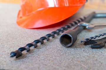 A red hard hat sits on top of a pile of tools