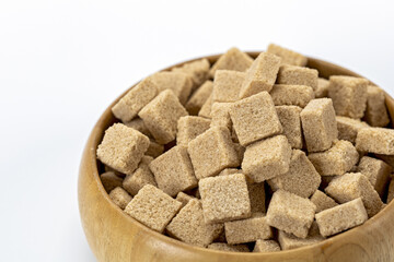 Organic brown sugar cubes in wooden bowl isolated on white background natural sweetener healthy ingredient rustic kitchen close up food concept clean eating minimal style