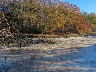ice on the bed of The River Hamble Hampshire England on a cold frosty winter day with blue sky in the background