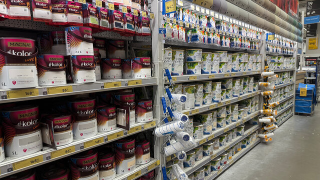 Warsaw, Poland - August 09, 2025: Colorful paint cans neatly arranged on shelves in a home improvement store