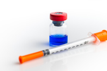 Close up of Blue Vial with Peptide Blend Next to Insulin Syringe (KLOW blend with GHK-Cu and KPV)