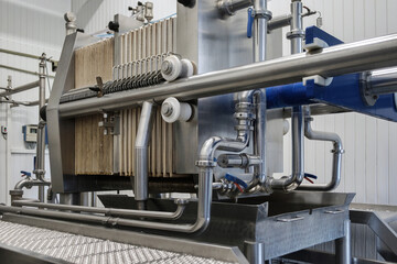 Steel pipelines, tubes and tanks at brewery. Close up of beer production filters