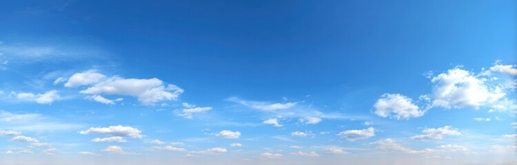 Wide view of a bright blue sky with scattered, fluffy white clouds, creating a peaceful and serene atmosphere