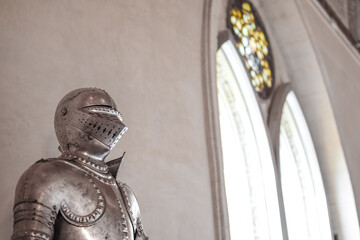 Side view of Medieval shiny armor and gothic pointed arches in white background