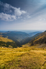 Fototapeta premium A solo traveler experiences a breathtaking autumn day in the wild Carpathian Mountains, near Lake Galcescu, in the Parang Mountains of Romania, where vibrant fall colors meet rugged peaks