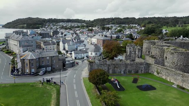 Aerial view of  the medieval ruins of Beaumaris Castle and the coastal town of Beaumaris on the Isle of Anglesey in Gwynedd off the north Wales coast. The castle dates from around 1295.