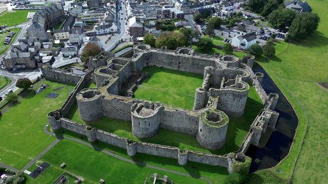 Aerial view of  the medieval ruins of Beaumaris Castle and the coastal town of Beaumaris on the Isle of Anglesey in Gwynedd off the north Wales coast. The castle dates from around 1295.