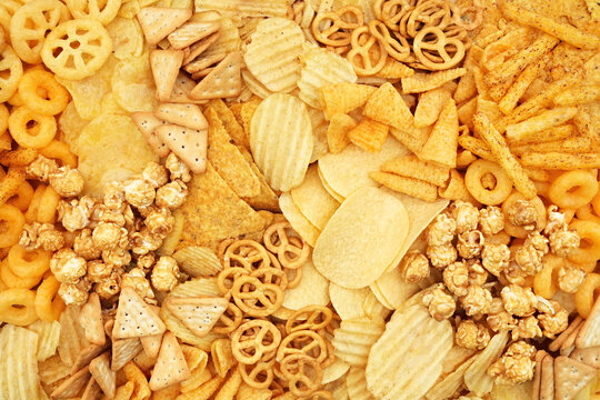 Colorful mix of salty snacks for beer varieties: chips and pretzels, rings and crackers. Non-healthy junk food background