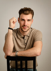 Studio portrait of a handsome young man sitting against isolated background