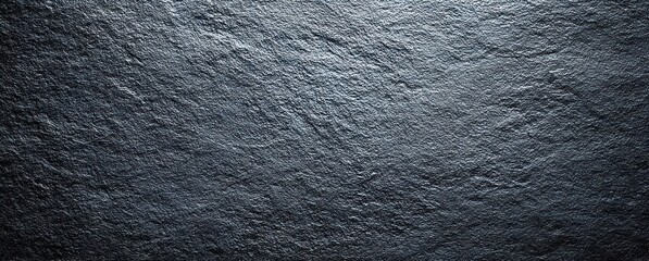 A dark, textured stone surface. Subtle highlights create depth and dimension across the rough, craggy planes of the stone