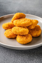 Golden crispy chicken nuggets on plate