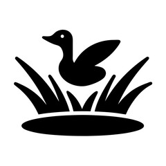 Black silhouette of a duck in tall grass by water