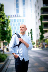 Confident middle aged man walking along a city street and sightseeing