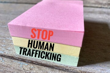 Written message Stop Human Trafficking on colourful sticky notes. 