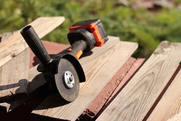 Cordless grinder with metal cutting disc, close-up. Repair at the cottage or construction. Compact...