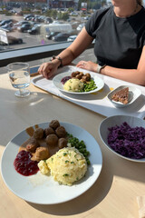 meatballs with gravy, creamy mashed potatoes, lingonberry sauce, green peas and red cabbage salad by the window—affordable, hearty, family-friendly