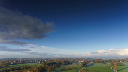 Obraz premium Breathtaking balcony view overlooking the lush green fields of Holland's countryside during a misty summer sunrise near Amsterdam, Netherlands