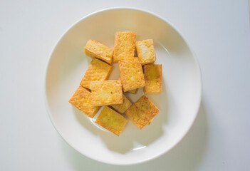 Crispy crackers on a white plate on a white background