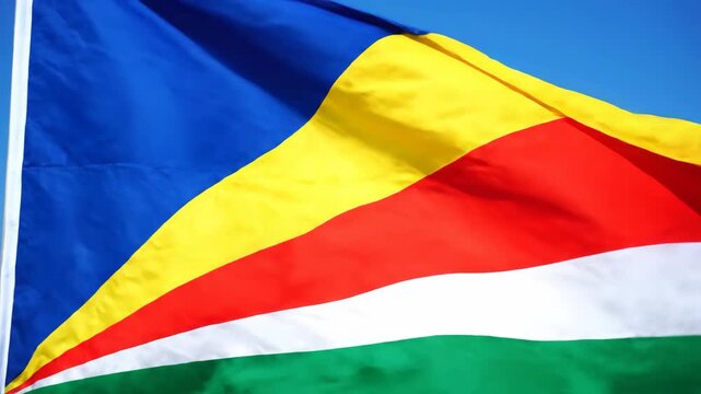 Seychelles Flag Waving Brightly Against a Clear Blue Sky During Daytime, National Symbol Blowing in the Wind