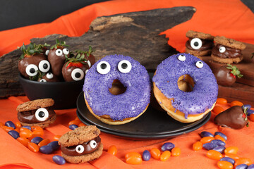 Doces decorados para festa de halloween: morangos, frutas, chocolates, cookies e donuts