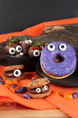 Doces decorados para festa de halloween: morangos, frutas, chocolates, cookies e donuts