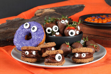 Doces decorados para festa de halloween: morangos, frutas, chocolates, cookies e donuts