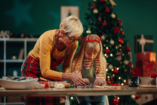 Grandmother and granddaughter making christmas cookies together