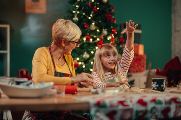 Grandmother and granddaughter baking christmas cookies together