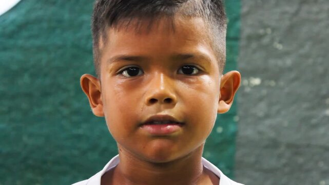 Portrait of a Colombian soccer player in a white uniform smiling and looking at the camera while training inside a gym in Neiva, Huila, Colombia. Concept of childhood 