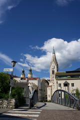 Scenic view of historic architecture with a bridge and church under a bright blue sky in a charming town