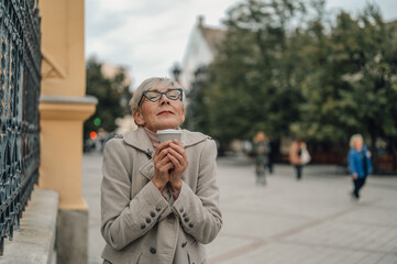 Senior woman enjoying a coffee break in the city