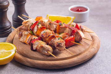 Delicious grilled chicken skewers with capsicum, lemon, salad and ketchup on a plate over the table. Chicken kebab. Healthy food concept.