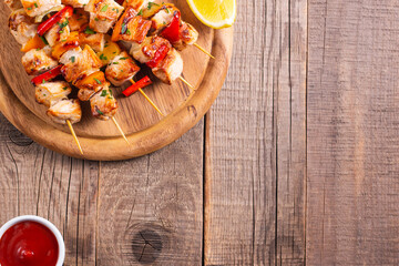 Delicious grilled chicken skewers with capsicum, lemon, salad and ketchup on a plate over the...