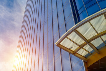 Modern glass skyscraper with sunlight reflection and architectural details