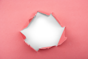 Abstract close-up of torn pink paper revealing a dark void behind