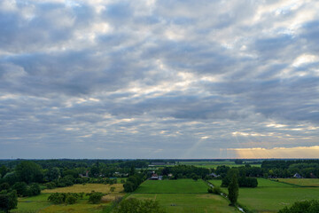 Breathtaking balcony view overlooking the lush green fields of Holland's countryside during a stormy summer sunset near Amsterdam, Netherlands