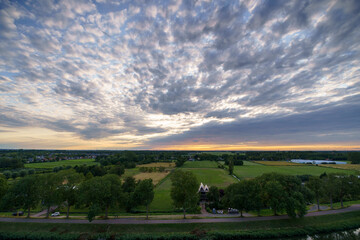 Obraz premium Breathtaking balcony view overlooking the lush green fields of Holland's countryside during a stormy summer sunset near Amsterdam, Netherlands
