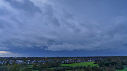 Breathtaking balcony view overlooking the lush green fields of Holland's countryside during a stormy summer sunset near Amsterdam, Netherlands