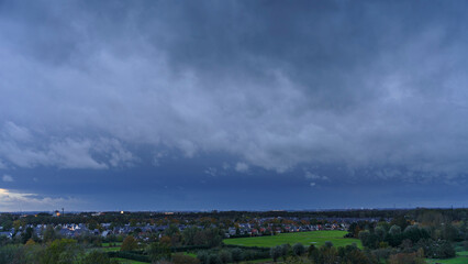 Breathtaking balcony view overlooking the lush green fields of Holland's countryside during a stormy summer sunset near Amsterdam, Netherlands