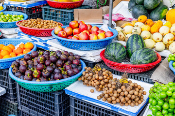 Colorful fruit market display with variety of fresh produce in plastic baskets