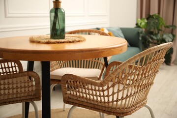Wooden table and stylish chairs in dining room, closeup